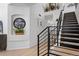 Bright foyer with hardwood floors, featuring a staircase, decor, and an accent wall with a built-in display niche at 9877 Arthur Ln, Highlands Ranch, CO 80130
