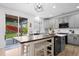 Open kitchen featuring an island with seating, gray cabinets, and a sliding glass door to the backyard at 9877 Arthur Ln, Highlands Ranch, CO 80130