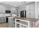 Modern kitchen features gray cabinets, stainless steel appliances, and a center island with stool seating at 9877 Arthur Ln, Highlands Ranch, CO 80130