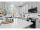 Modern kitchen boasts white quartz countertops, sleek appliances, and stylish light gray cabinets with dark hardware at 9877 Arthur Ln, Highlands Ranch, CO 80130