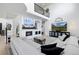 Bright living room with a fireplace, two large TVs, and a comfortable white sectional sofa at 9877 Arthur Ln, Highlands Ranch, CO 80130