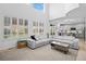 Bright living room featuring a white sectional sofa, hardwood floors, and natural light from large windows at 9877 Arthur Ln, Highlands Ranch, CO 80130