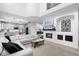 Open-concept living room with a fireplace, a modern kitchen, and a comfortable white sectional sofa at 9877 Arthur Ln, Highlands Ranch, CO 80130
