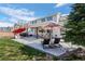 Enjoyable patio space with ample seating, a covered area, and lush landscaping at 9877 Arthur Ln, Highlands Ranch, CO 80130
