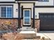 Cozy front porch area showing brickwork detail, black pillars, and a welcoming glass storm door entrance at 2853 Black Canyon Way, Castle Rock, CO 80109