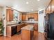 Eat-in kitchen with stainless steel appliances, island, granite countertops, wooden cabinetry, and hardwood floors at 2853 Black Canyon Way, Castle Rock, CO 80109