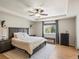 Comfortable main bedroom featuring neutral colors, tray ceiling, dark wood furnishings, and a sitting bench at 2853 Black Canyon Way, Castle Rock, CO 80109