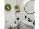 Charming powder room with wainscoting, decorative mirror, and a stylish pedestal sink at 2853 Black Canyon Way, Castle Rock, CO 80109