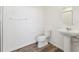 Bright bathroom featuring a toilet, sink, mirror, and shower with wood-look flooring at 6910 Merseyside Ln, Castle Pines, CO 80108