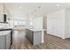 Contemporary kitchen featuring a kitchen island, hardwood floors, and stainless steel appliances at 6910 Merseyside Ln, Castle Pines, CO 80108