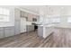 Bright, modern kitchen with gray cabinetry, an island, and wood floors in an open layout at 6910 Merseyside Ln, Castle Pines, CO 80108