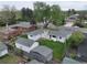 Aerial view of the property showcasing the house, sheds, lush green lawn, mature trees, and the surrounding neighborhood at 14185 W 50Th Ave, Golden, CO 80403