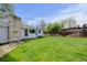 Expansive backyard with lush green grass, white brick chimney and a wooden fence at 14185 W 50Th Ave, Golden, CO 80403