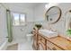 Bathroom features a wood vanity, modern sink and fixtures, and a bright window for natural light at 14185 W 50Th Ave, Golden, CO 80403