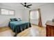 Serene bedroom featuring hardwood floors, a ceiling fan, and large windows offering natural light at 14185 W 50Th Ave, Golden, CO 80403
