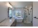 Modern bathroom featuring double sinks, soaking tub, and stylish tiled shower at 294 Willowick Cir, Highlands Ranch, CO 80129