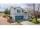 An elevated view of a two-story home, featuring a fence, lawn, two-car garage, and vibrant blue shutters at 294 Willowick Cir, Highlands Ranch, CO 80129