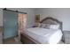 Cozy main bedroom with a barn door to the bathroom, and a decorative bed with plush pillows at 294 Willowick Cir, Highlands Ranch, CO 80129