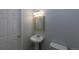 Powder room with a pedestal sink, mirror, toilet and white fixtures at 294 Willowick Cir, Highlands Ranch, CO 80129