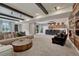 Spacious basement boasts exposed beams, a large sectional, and an adjacent bar area, perfect for entertaining guests at 5251 Silver Hare Ct, Castle Rock, CO 80104