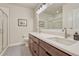 Bathroom with double sinks, wood cabinets, quartz countertops, and tiled shower at 5251 Silver Hare Ct, Castle Rock, CO 80104