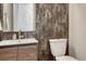 Modern bathroom features a dark accent wall, wood vanity, and modern fixtures at 5251 Silver Hare Ct, Castle Rock, CO 80104