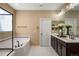 Bathroom features a jacuzzi tub, a dual sink vanity with dark cabinets and a bright, well-lit mirror at 10055 Fort Worth Ct, Parker, CO 80134