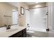 Clean bathroom featuring dark cabinets, a white tile shower, and a classic bronze faucet at 10055 Fort Worth Ct, Parker, CO 80134