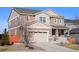 Two-story home featuring neutral siding, stone accents, attached two-car garage, covered porch, and well-maintained landscaping at 10055 Fort Worth Ct, Parker, CO 80134