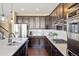 Gourmet kitchen with stainless steel appliances, dark cabinets, and a bright white quartz countertop at 10055 Fort Worth Ct, Parker, CO 80134