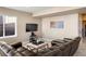 Living room with a large leather sectional sofa and large TV at 10055 Fort Worth Ct, Parker, CO 80134