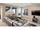 Living room with a large leather sectional sofa and three large windows for natural light at 10055 Fort Worth Ct, Parker, CO 80134