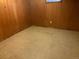Spacious basement area featuring wood paneling, vintage tile flooring, and a small window at 3054 Victor St, Aurora, CO 80011