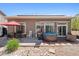 Backyard patio featuring an outdoor kitchen, dining area, hot tub, and green landscaping at 5471 Ensenada Ct, Denver, CO 80249