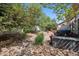 Landscaped backyard oasis, featuring mature trees, rock beds, and a relaxing hot tub at 5471 Ensenada Ct, Denver, CO 80249