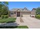 Charming home with a well-manicured lawn, stone accents, and an attached two-car garage at 5471 Ensenada Ct, Denver, CO 80249
