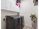 Laundry room features a washer and dryer, white cabinets, and decorative statue at 5471 Ensenada Ct, Denver, CO 80249