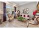 Bright living room with hardwood floors, three oval mirrors, and two chairs with decorative cushions at 5471 Ensenada Ct, Denver, CO 80249