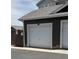 Detached garage with a white door, showing unit number and adjacent parking at 14700 E 104Th Ave # 1105, Commerce City, CO 80022