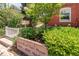 Landscaped front entrance with address sign, greenery, and a glimpse of the building's brick facade at 1824 Pearl St # B, Boulder, CO 80302