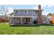 The home's backyard features a covered patio, a brick chimney, and a well-maintained lawn at 12945 E Colorado Ave, Aurora, CO 80012
