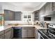 Modern kitchen featuring gray cabinets, stainless steel appliances, and ample counter space at 12945 E Colorado Ave, Aurora, CO 80012
