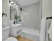 Clean bathroom with a single vanity, bathtub, and marble tile at 1361 W Custer Pl, Denver, CO 80223