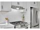Stylish kitchen showcasing white cabinets, quartz countertops, and a subway tile backsplash at 1361 W Custer Pl, Denver, CO 80223