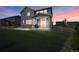Backyard with a covered patio and sliding glass doors as dusk sets at 6802 S Uriah St, Aurora, CO 80016