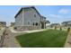 Exterior view of the home featuring a green lawn and covered porch at 6802 S Uriah St, Aurora, CO 80016