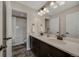 Bathroom featuring double sinks, modern fixtures, and a separate shower with a bathtub at 6802 S Uriah St, Aurora, CO 80016