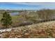 Picturesque community view with a lake, snow, and native grasses presents a serene landscape at 6802 S Uriah St, Aurora, CO 80016