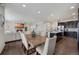 Open concept dining area with wood table flowing into a modern kitchen and living room at 6802 S Uriah St, Aurora, CO 80016