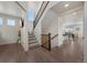 Bright and open foyer featuring hardwood floors, a staircase with wooden railings, and views into the kitchen area at 6802 S Uriah St, Aurora, CO 80016